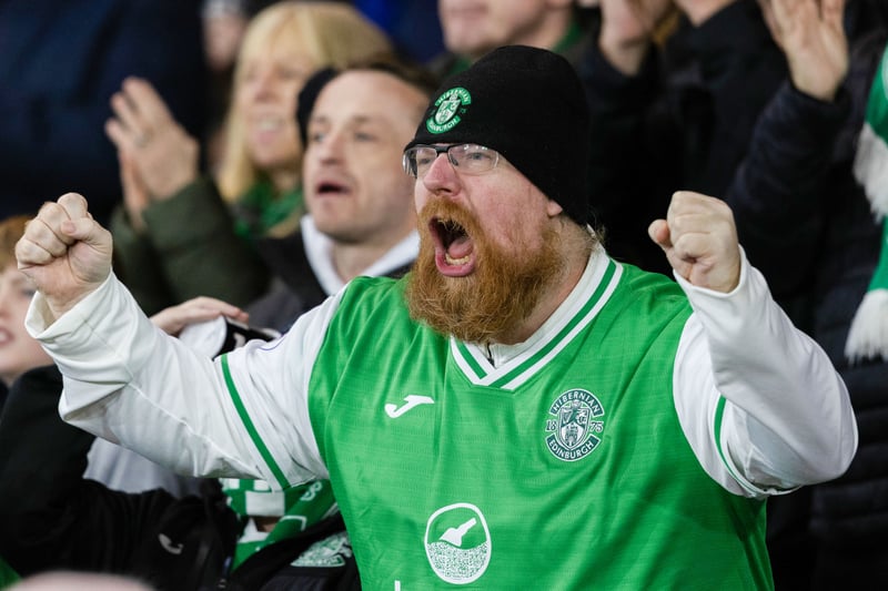 A Hibs FC fan cheers on his team against the Dons