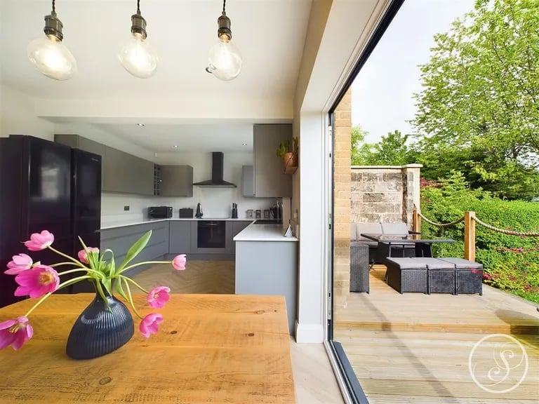 The glass bi-folding doors open to the decked terrace in the garden.