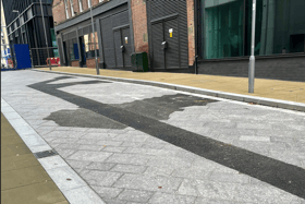 Asphalt cutting through granite pavement on Wellington Street.
