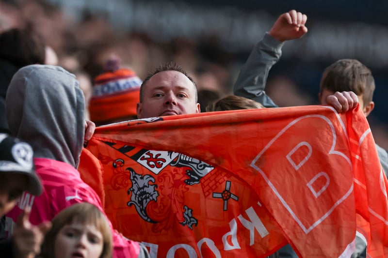 A Blackpool fan proudly shows his flag to the camera. 