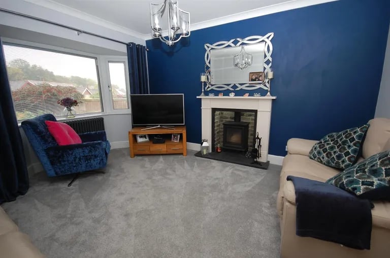 This spacious lounge with large bay window has a log burner.