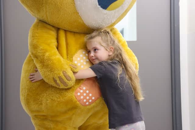 A young girl hugs mascot Theo after a scan at Sheffield Children's Hospital