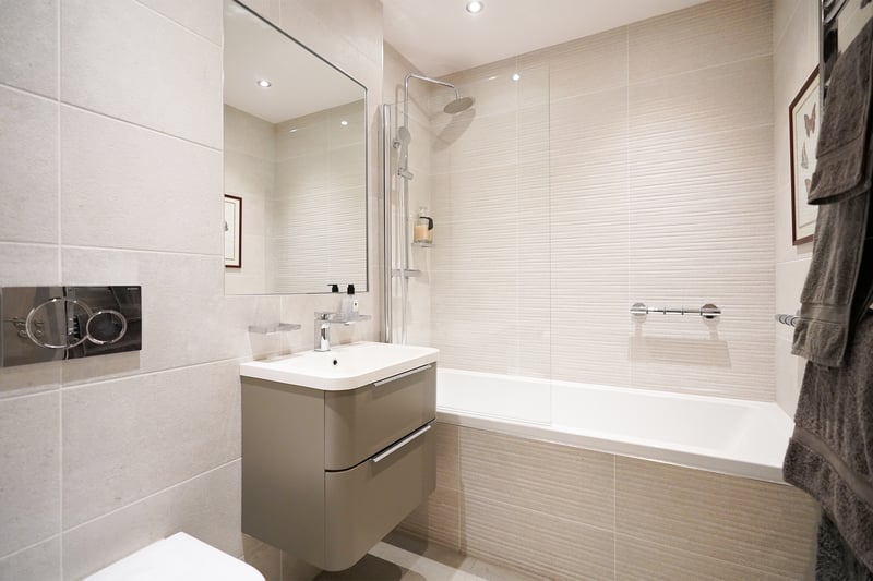 The bathroom has an overhead shower, bath with plenty of space for relaxing, and modern design completed with a high-quality finish.