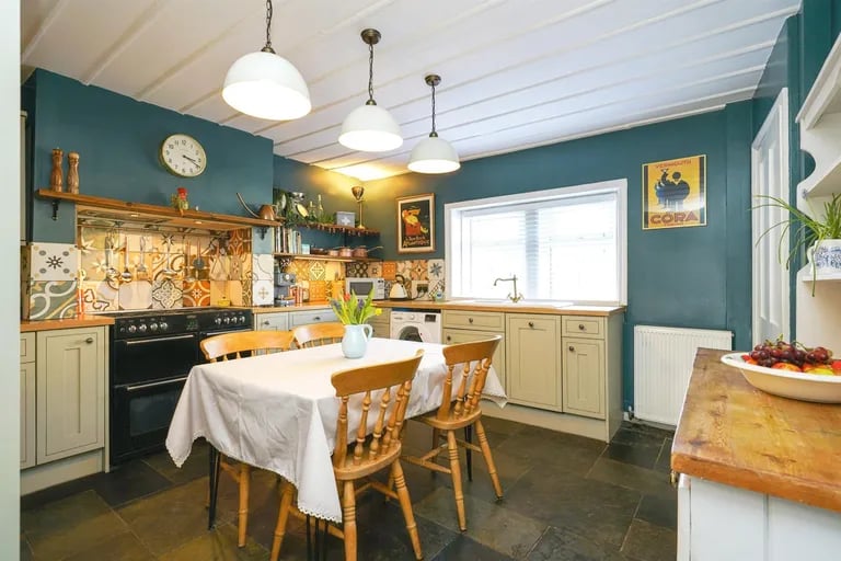 The country cottage style fitted kitchen with a range of wall and base units with wood effect.