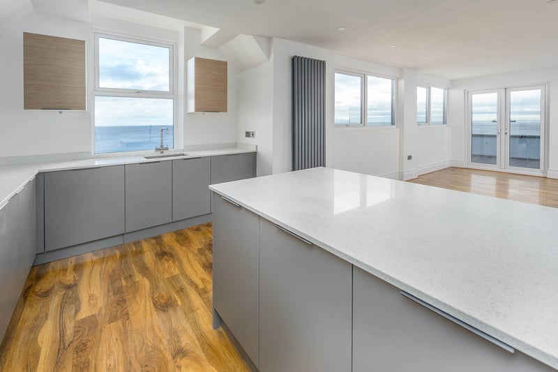 The penthouse apartment features a very spacious and modern kitchen area.