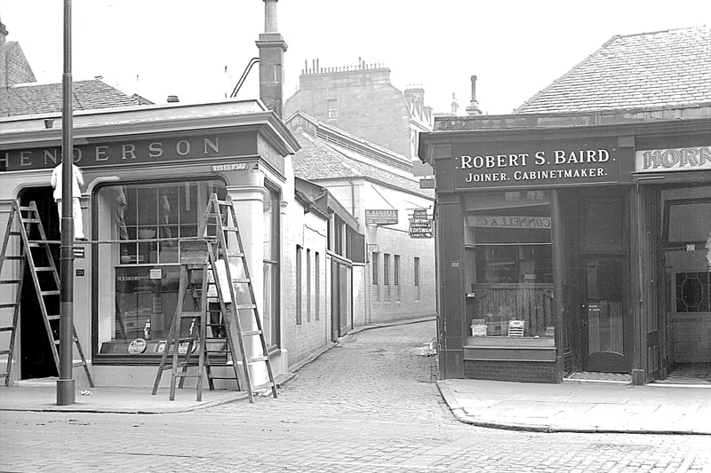 Decorators work away on a shop front at the entrance of Ashton Lane which many a Glaswegian will have walked up over the years. 