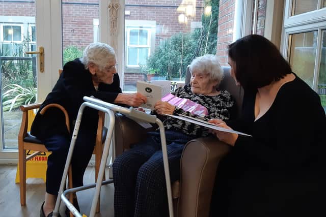 Edith opens her birthday card from the King, with her sister Margaret Elam and great-niece Nicola.