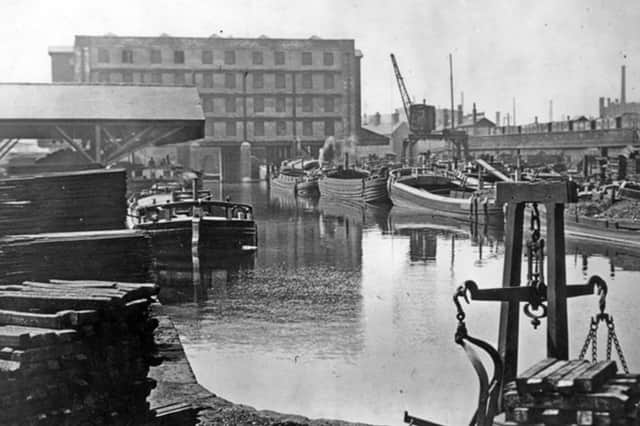 Victoria Quays, Sheffield, in the 1920s or 30s, showing the Straddle building to the rear and the railway arches on the right. The Straddle, a former grain warehouse which has been converted to offices, and the arches, which now house a range of businesses including pubs and cafes, are both listed for auction