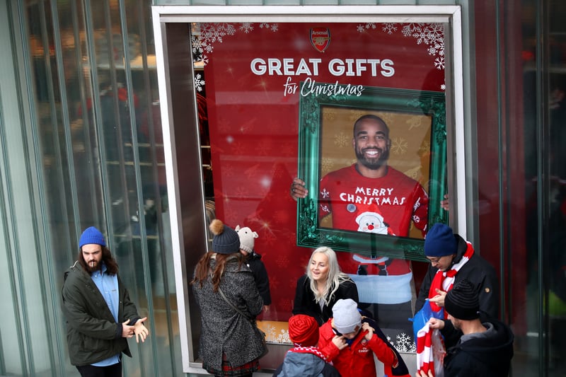 Arsenal fans in Christmas jumpers celebrate a 2-1 victory over Manchester City. Theo Walcott and Oliver Giroud were the scorers on the day. (Getty Images)