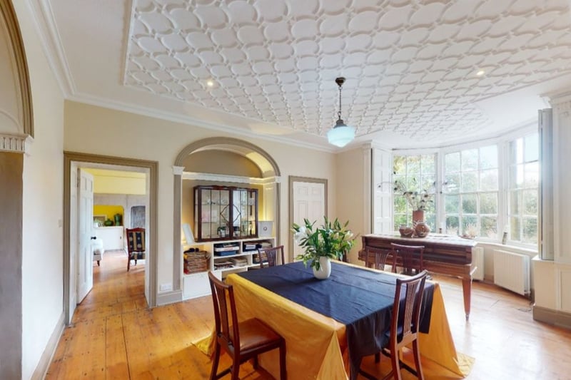 The dining room includes large3 bay windows looking out onto the surrounding private woodland.