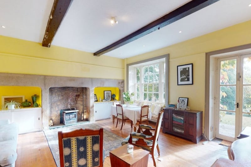 One of seven reception rooms, this lounge includes patio doors and exposed wooden beams.