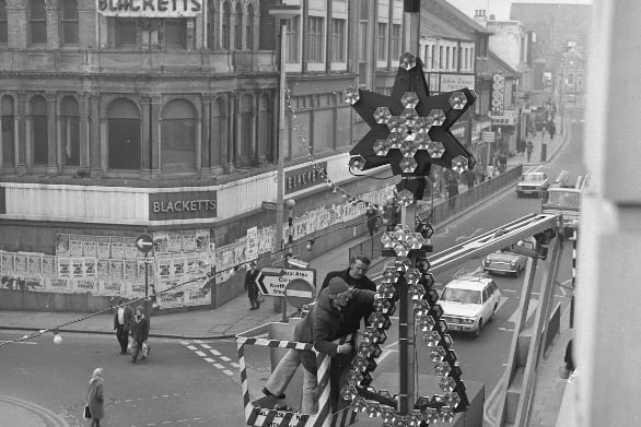 Braving the heights to put up the High Street West lights in 1974.