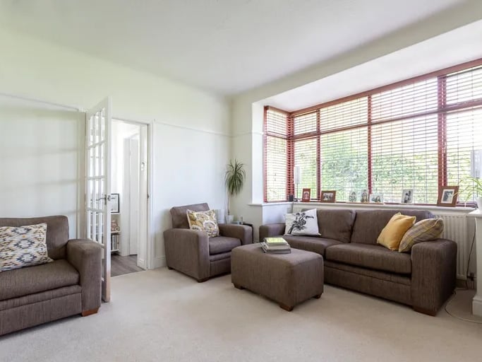 The relaxing living room has a large bay window.