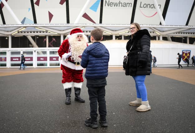 A fan of West Ham United speaks with Father Christmas outside the London Stadium.