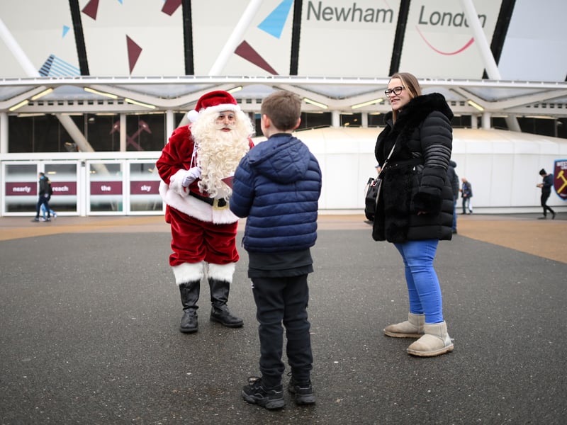 A fan of West Ham United speaks with Father Christmas outside the London Stadium.