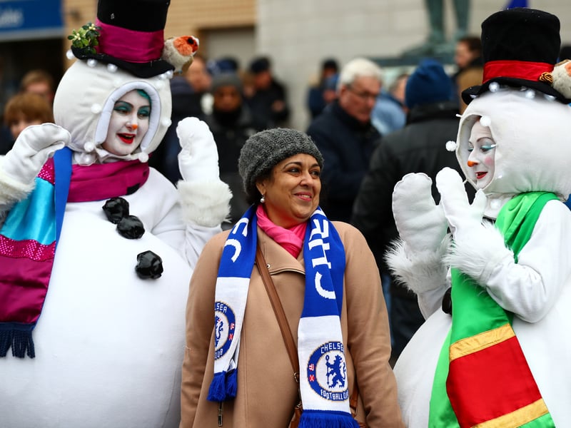 A Chelsea fan has a photo taken with some Christmas snowmen