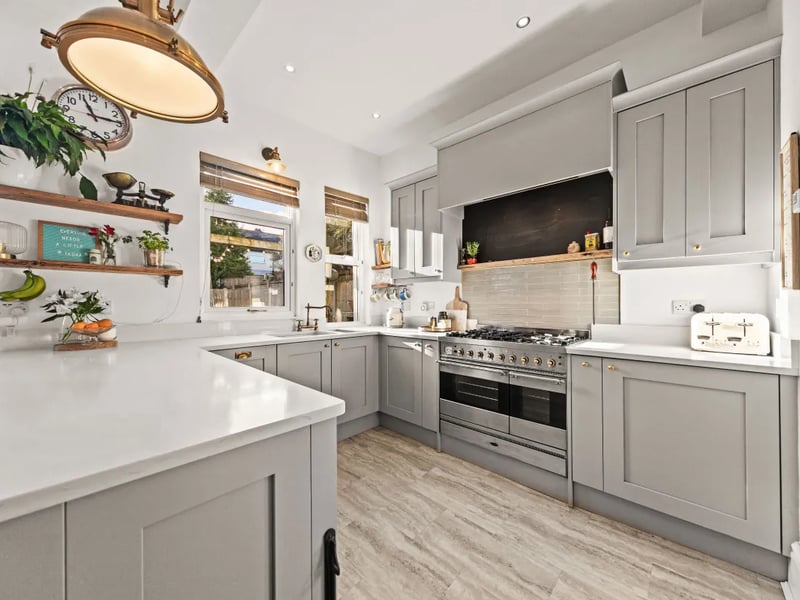 The modern kitchen with a range of base and wall units as well as integrated appliances.