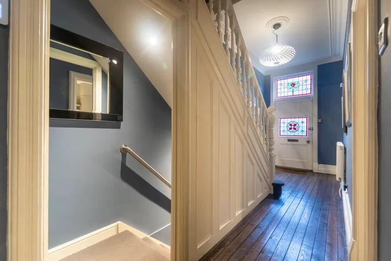Enter into the hallway with wooden floors.