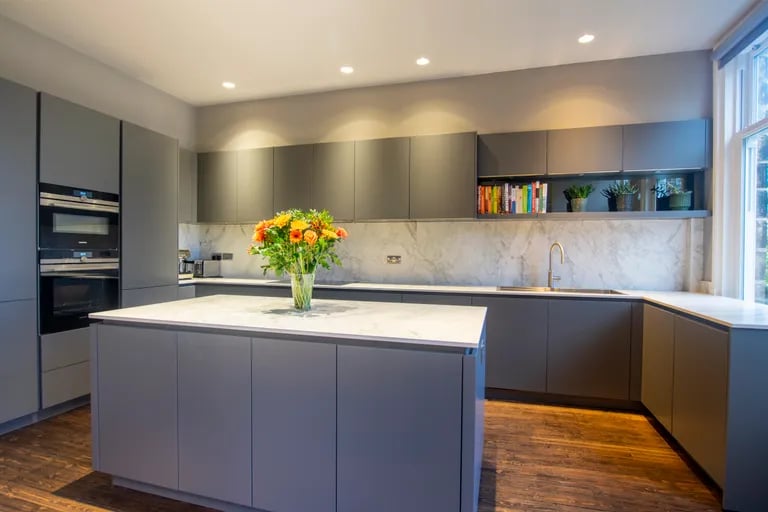 The modern bespoke kitchen with base and wall units and central island.