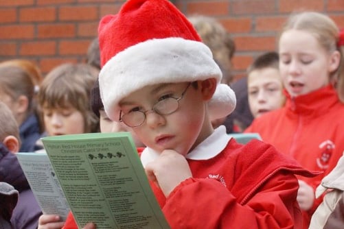 Southwick Market at Christmas in 2006. This young Santa looks deep in thought as he examines in the song sheet