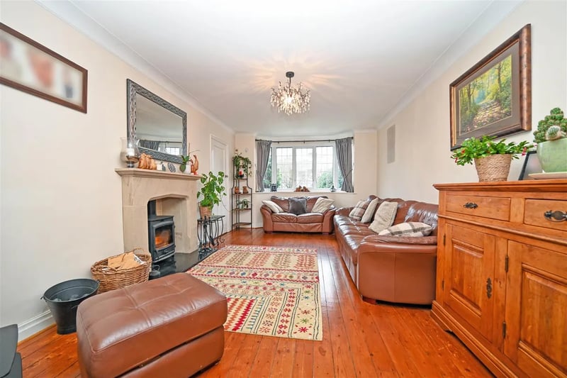 The spacious living room has a fireplace and stripped wooden floors.