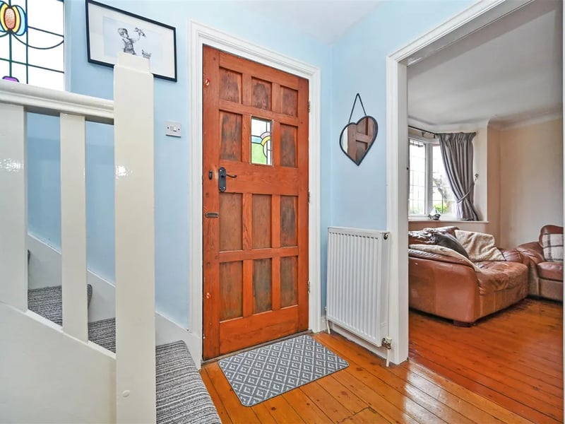 Enter into this bright hallway with stripped wooden floors.