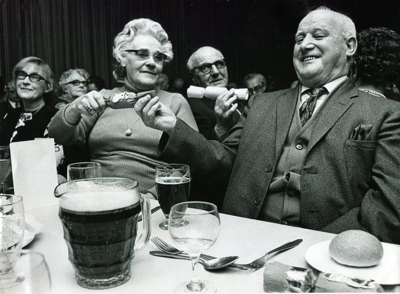 Mr and Mrs Bill and Winnie Evetts pull a cracker at the Tinsley Wire Industries retired persons annual Christmas dinner on December 13, 1973