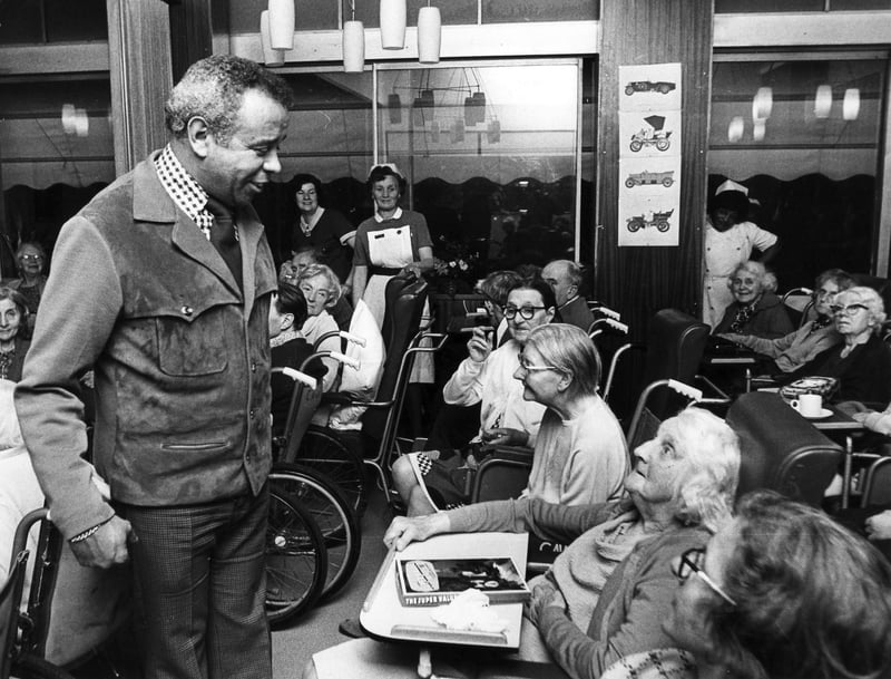The comedian Charlie Williams pays a visit to Nether Edge Hospital, Sheffield, where older residents were enjoying a Christmas party paid for by the De La Salle School football section in December 1974