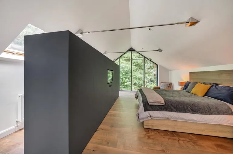 The stunning master bedroom with glass gable end and built-in clothes storage.