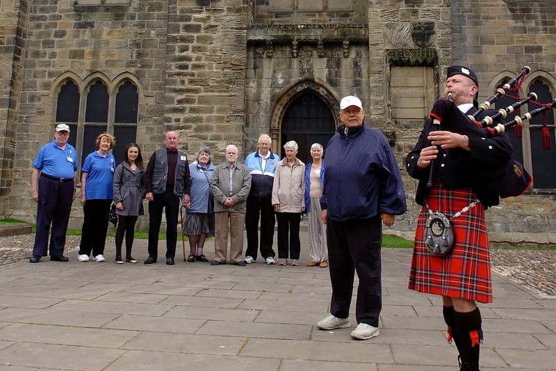 Earl Hilton, from Midlothian, Virginia, and his fellow Americans hear a lament from piper Richie Duffy on a visit to Hylton Castle, their ancestoral family seat.