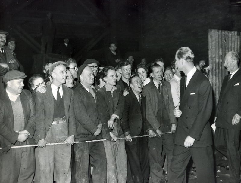 Workers in the Heavy Forge give the Duke of Edinburgh a cheer after he leaves the controls of the giant press during his tour of Hadfield's on October 24, 1957