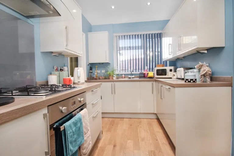 A modern kitchen with a range of fitted base and wall units and appliances.