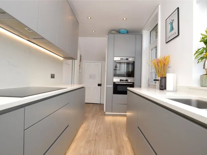The modern kitchen with a range of base and wall units.