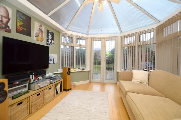 A spacious conservatory with glass ceiling overlooks the rear garden.