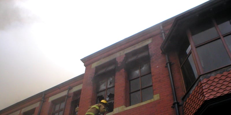 A firefighter inspects one of the upper floor rooms
