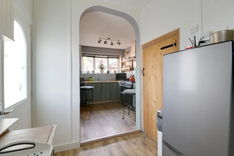 Behind the kitchen is a handy utility space.