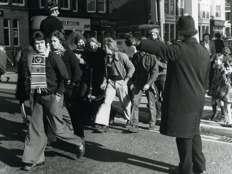 Police escourting Manchester United supporters through the streets of Blackpool for the match at Bloomfield Road in October 1974