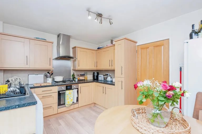 The kitchen is fitted with a range of base and wall units and appliances.