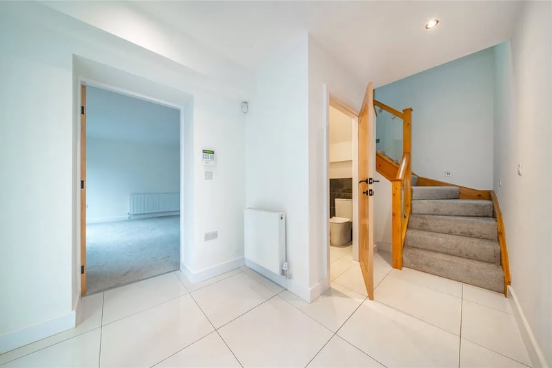 Enter into a well-proportioned entrance hall with tiled flooring and a guest WC.