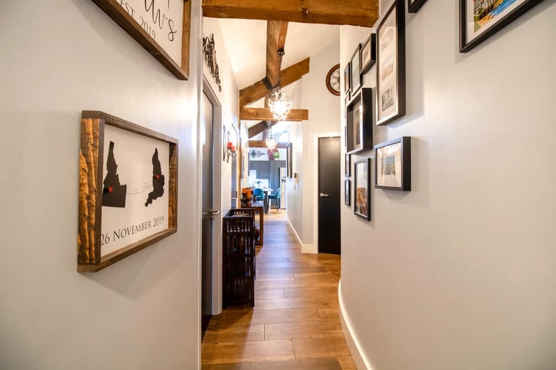 Enter into a spacious hallway with full height ceilings with exposed beams.