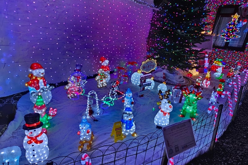 Lots of snow people and reindeer are chilling by the entrance to the North Pole.
