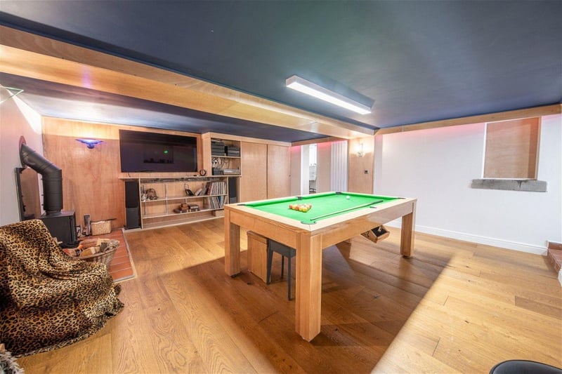 This room could be the fourth bedroom of the home. It is currently used as a home gym and games room. To the left is a cosy log burner. Photo courtesy of Zoopla 