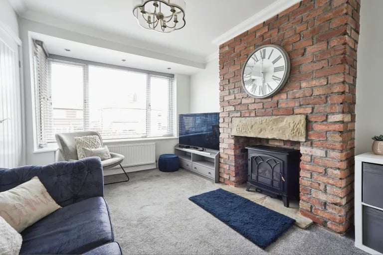 The lounge with feature fireplace and exposed brick chimney.
