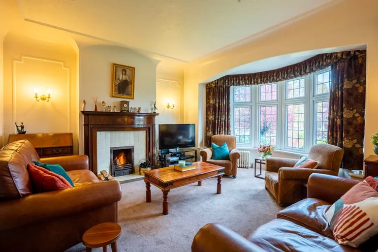 The stunning living room has large bay window and fireplace.