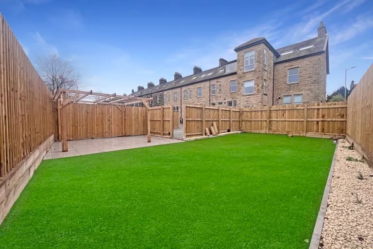 The large enclosed garden has a large lawn and patio areas.