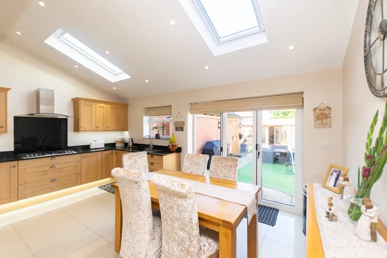 The dining area has glass doors to the rear garden and skylights.