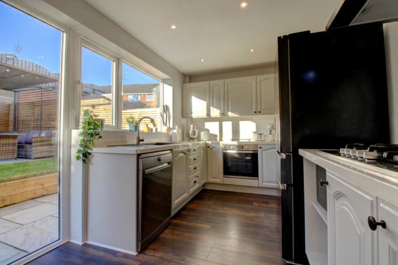 The bright kitchen is fitted with modern base and wall units and appliances and overlooks the rear garden.