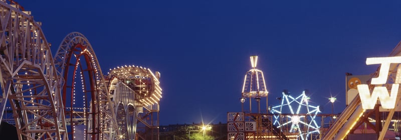 A night view of the illuminated rollercoaster and fun rides 