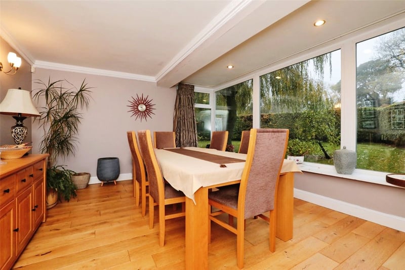The dining area is set close to large windows, looking out onto the spacious garden.