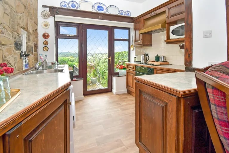 The kitchen offers a mix of period charm and modern amenities with great views of the rear garden.